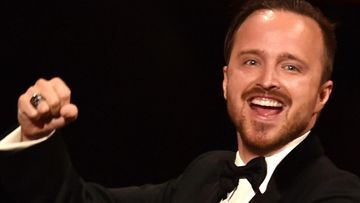 Aaron Paul punches the air while accepting the best supporting actor award at the Emmys.