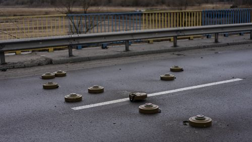 Miny przeciwczołgowe są rozrzucone na moście w Buczy, na obrzeżach stolicy Ukrainy, Kijowa. 