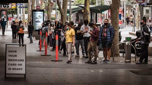 People queue for a COVID-19 test on Bourke Street in Melbourne.