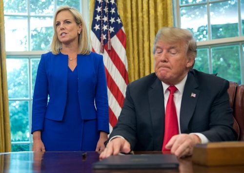 Trump listens as Homeland Security Secretary Kirstjen Nielsen addresses members of the media before Mr Trump signs an executive order to end family separations at the border.