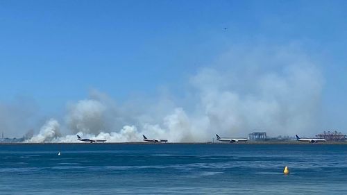 Images taken from a nearby beach show smoke from third runway at Sydney Airport.