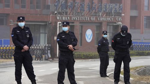 Security personnel gather near the entrance of the Wuhan Institute of Virology in February 2021.