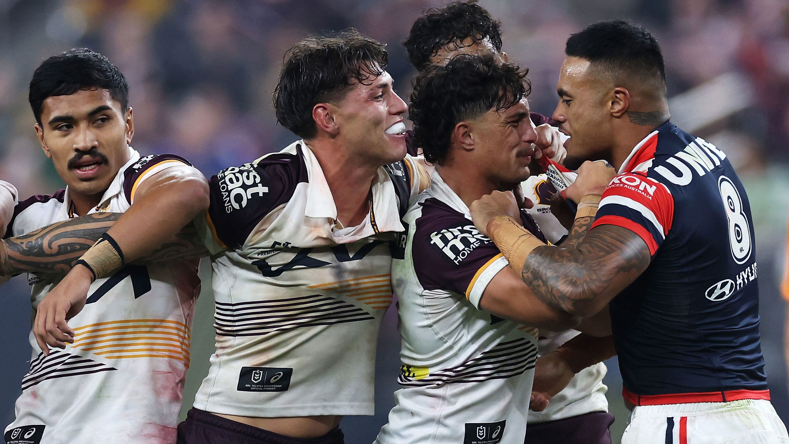 Kotoni Staggs and Broncos teammates confront Roosters player Spencer Leniu.