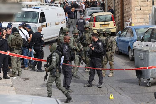 Israeli security forces and emergency service personnel gather at a cordoned-off area in Jerusalem's predominantly Arab neighbourhood of Silwan, where an assailant reportedly shot and wounded two people, on January 28, 2023.