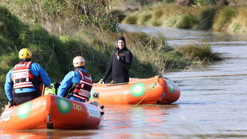 The police dive squad search the Halswell River, south of Christchurch, on Wednesday.