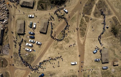 People wait in a queue to cast their vote at a polling station in Harare, Zimbabwe, Monday, July 30, 2018. Zimbabweans on Monday voted in their first election without Robert Mugabe on the ballot, a contest that could bring international legitimacy and investment or signal more stagnation if the vote is seriously flawed. (AP Photo/Bram Janssen) 