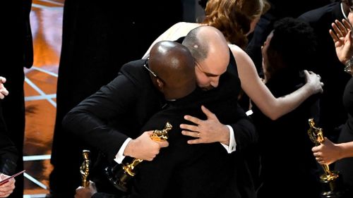 The producer embraces Moonlight director Barry Jenkins. (Getty)