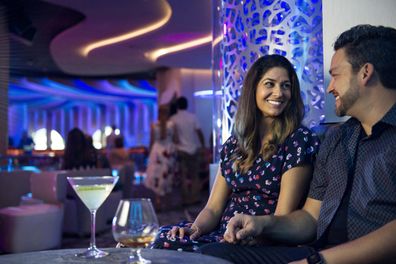 A couple sits in a bar with a drink