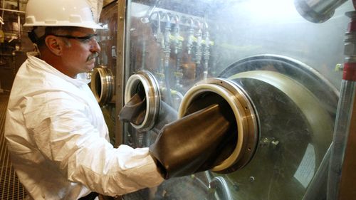 David Ardoin, an operator for Parsons Infrastructure and Technology Group Inc. of Pasadena, Calif. demonstrates the enclosed CHATS system where the nerve agent VX is drained from the ton containers to begin the process of chemically neutralizing the stockpile. (AP)