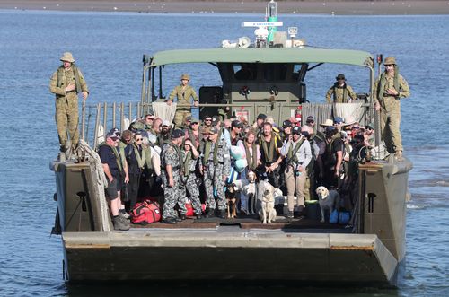 Mallacoota evacuees are brought to shore on landing crafts in Hastings.