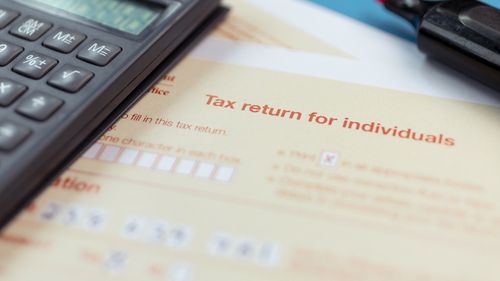 Generic picture of someone filling out a tax return.