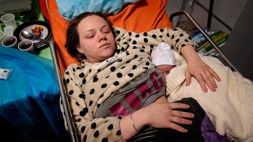 Mariana Vishegirskaya lies in a hospital bed after giving birth to her daughter Veronika, in Mariupol, Ukraine.