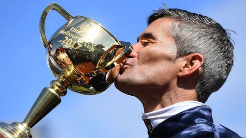 Winning jockey Corey Brown kisses the cup. (AAP)