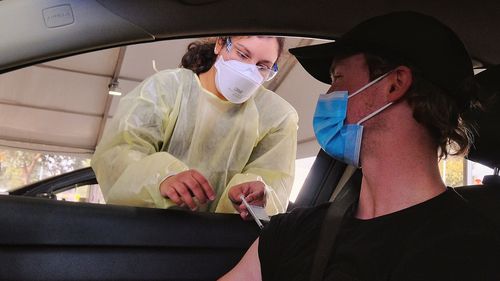 Driver Justin Somerville waiting to be vaccinated at Eagle Stadium in Werribee, Victoria.