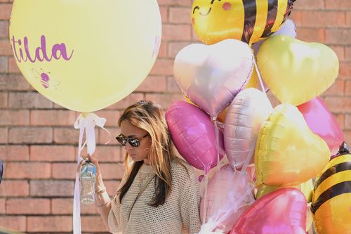 A woman carries balloons to the funeral of Bondi Beach mass shooting victim 10-year-old Matilda, whose last name is being withheld at the request of her family, in Sydney, Thursday, Dec. 18, 2025. (AP Photo/Steve Markham)