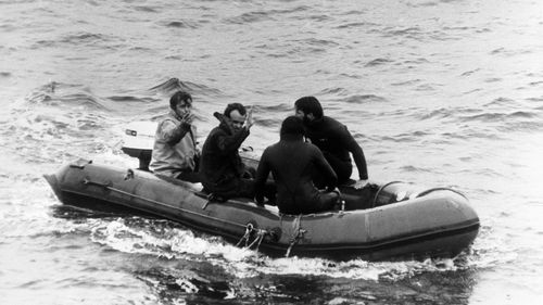 Roger Chapman (second left) waves as he is taken to the Vickers Voyager, after being released from the crippled miniature submarine Pisces III, which ahd been hauled over 1,000ft from the Atlantic seabed off Cork. 