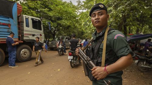 Um policial armado da Polícia Nacional do Camboja protege um caminhão de suprimentos em um campo de reassentamento, criado para abrigar milhares de pessoas que fogem do confronto Tailândia-Camboja, em Oddar Meanchey, Camboja, no domingo, 27 de julho de 2025