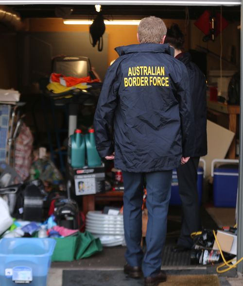 An Australian Border Force agent walks into a garage at the Bathurst address.