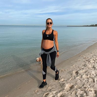 Steph Claire Smith on a walk with her dog on the beach while pregnant.