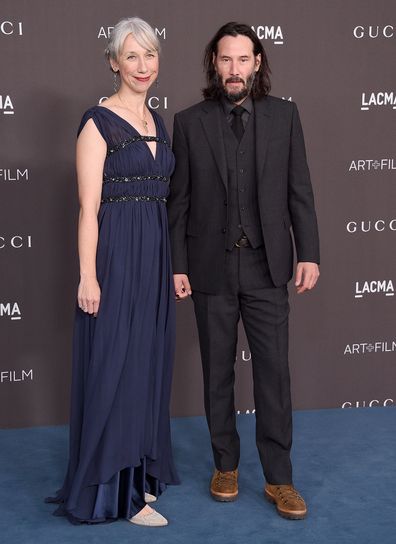 Keanu Reeves and Alexandra Grant pose on the carpet