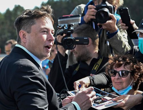Technology entrepreneur Elon Musk gives autographs as he visits the Tesla Gigafactory construction site in Gruenheide near Berlin