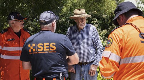 State Emergency Service (SES) workers speak to local resident Don Bray.