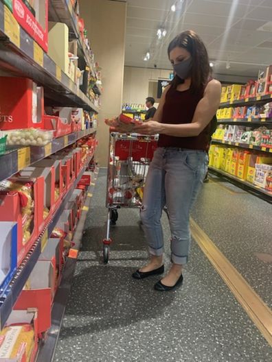 Jo Abi shopping at Aldi comparing products.