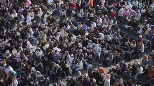 People gather in St. Peter's Square as they await the arrival of the body of Pope Francis, who will lie in state at St. Peter¥s Basilica for three days, at the Vatican, Wednesday, April 23, 2025. (AP Photo/Markus Schreiber)