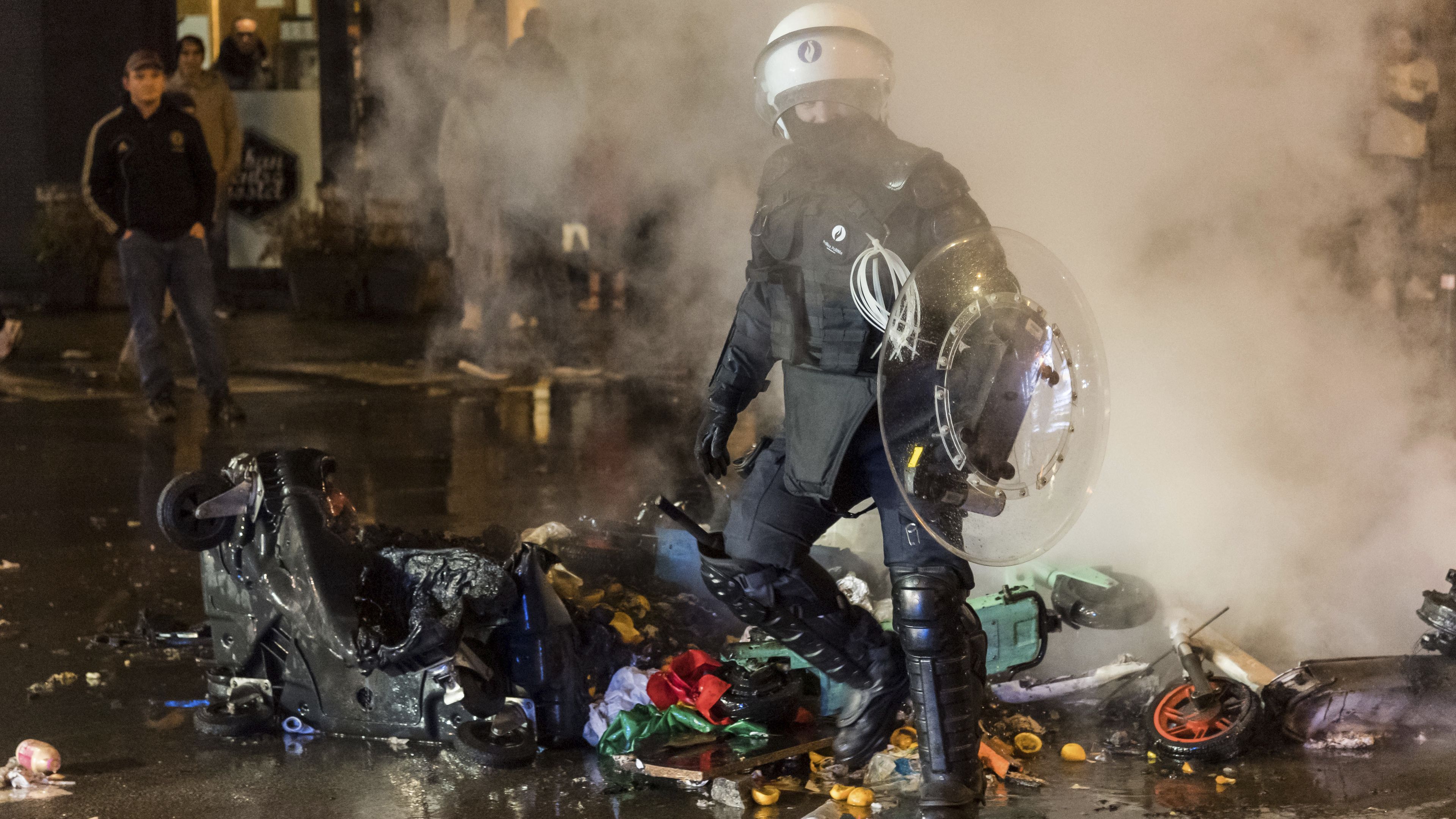 A riot police officer walks along a main boulevard in Brussels, Sunday, Nov. 27, 2022, as violence broke out during and after Morocco&#x27;s 2-0 win over Belgium at the World Cup. Police had to seal off parts of the center of Brussels and moved in with water cannons and tear gas to disperse crowds. (AP Photo/Geert Vanden Wijngaert)