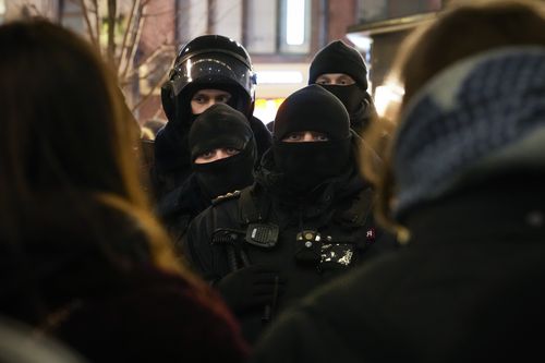 Police officers look at demonstrators in St. Petersburg, Russia, Thursday, Feb. 24, 2022. Hundreds of people gathered in Moscow and St.Petersburg on Thursday, protesting against Russia's attack on Ukraine. Many of the demonstrators were detained. Similar protests took place in other Russian cities, and activists were also arrested. (AP Photo/Dmitri Lovetsky)