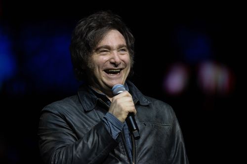 O presidente argentino Javier Milei sorri em show com banda durante apresentação de seu livro 'La Construccion del Milagro' na Movistar Arena em 06 de outubro de 2025 em Buenos Aires, Argentina.