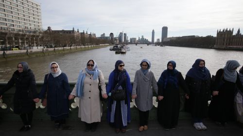 Women hold hands on Westminster Bridge to remember London attack victims