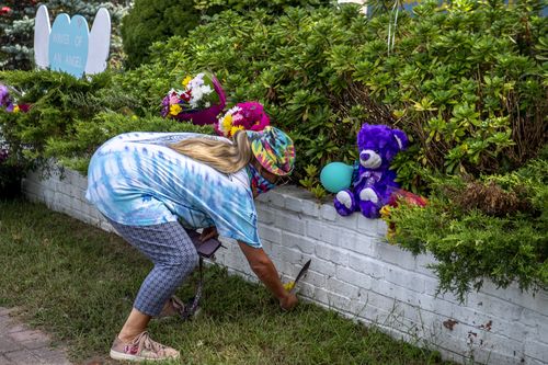 Dawn Bartell of Bohemia, NY brings flowers for Gabby Petito's memorial alongside Montauk Hwy in Blue Point, New York.
