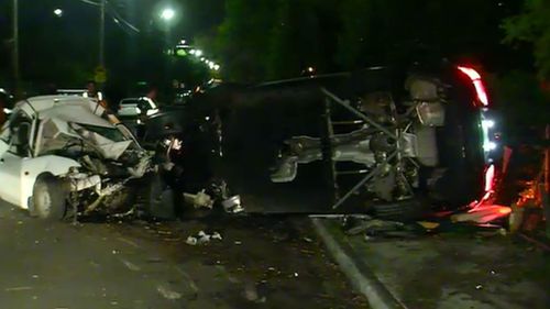 The BMW flipped onto its side after crashing into three parked cars. (9NEWS)