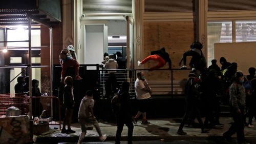 People rush into a Gucci store after it was broken into, in New York, as protests rage over the death of George Floyd.