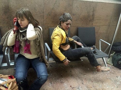 Two injured women sit dazed, confused and covered in dust in Brussels Airport in Belgium, on March 22, 2016. Twin bombings at Brussels airport and a metro station killed 32 people from around the world. Islamic State claimed responsibility for the attack.