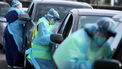 Registered Nurse Oli Meeta (c) and team members conduct COVID-19 swab tests as large crowds queue at a Bondi Beach drive-through testing clinic on July 22, 2020 in Sydney,  Australia.