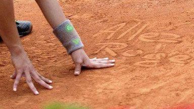 Roland Garros ball kid Kenza Del scrawls a message on the court for Roger Federer in 2011.