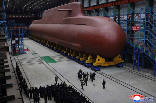 In this undated photo provided Thursday, Dec. 25, 2025, by the North Korean government, its leader Kim Jong Un inspects a nuclear-powered submarine under construction at an undisclosed location.