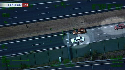 The men sprint into traffic chased by police. (9NEWS)