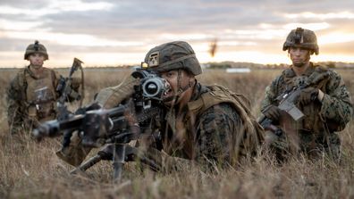 US Marine Private First Class Gabriel Gonzalez (centre), from 1st Battalion, 7th Marines, directs fire during an assault on Bowen Airport in Queensland, on Exercise Talisman Sabre 2021.