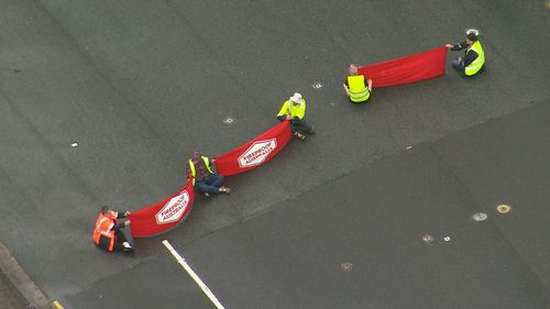 Protesters block Sydney's busy Spit Bridge causing major peak-hour traffic delays.