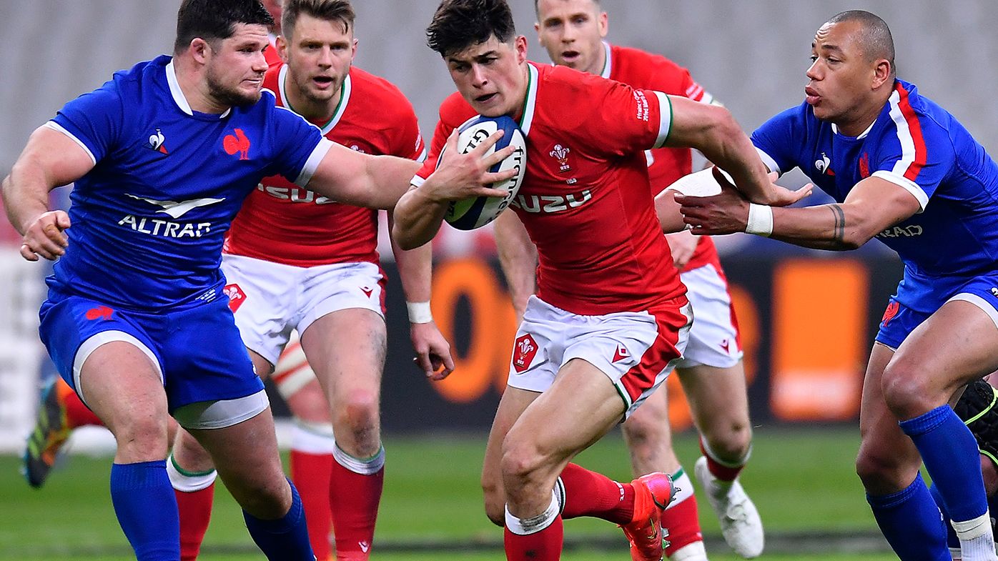 Louis Rees-Zammit of Wales breaks through the contact of (L-R) Julien Marchand and Gael Fickou of France during the Guinness Six Nations match between France and Wales at Stade de France on March 20, 2021 in Paris, France.