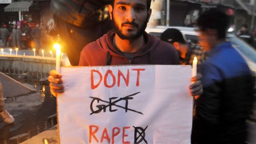 Demonstrators hold banners and light candles during a vigil in Anantnag, Kashmir on January 15, 2018. (AAP)