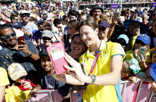 Swimmer Cate Campbell poses for a selfie with waiting fans on the Gold Coast this morning. (AAP)