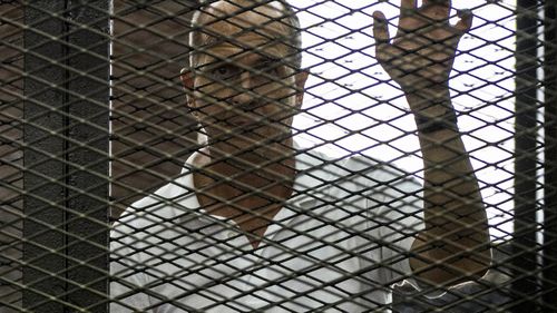 Peter Greste held in a cage in the courtroom. (AP)