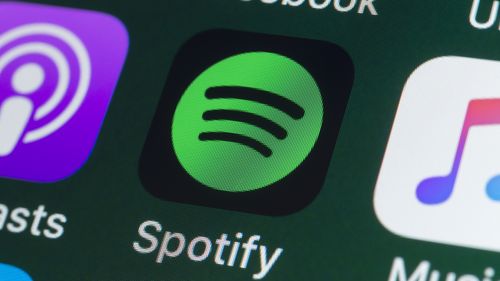 London, UK - July 31, 2018: The buttons of the music streaming app Spotify, surrounded by Podcasts, Apple Music, Facebook and other apps on the screen of an iPhone.
