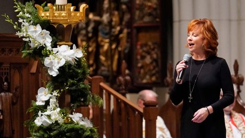 US singer Reba McEntire sings 'The Lord's Prayer' during a funeral service.