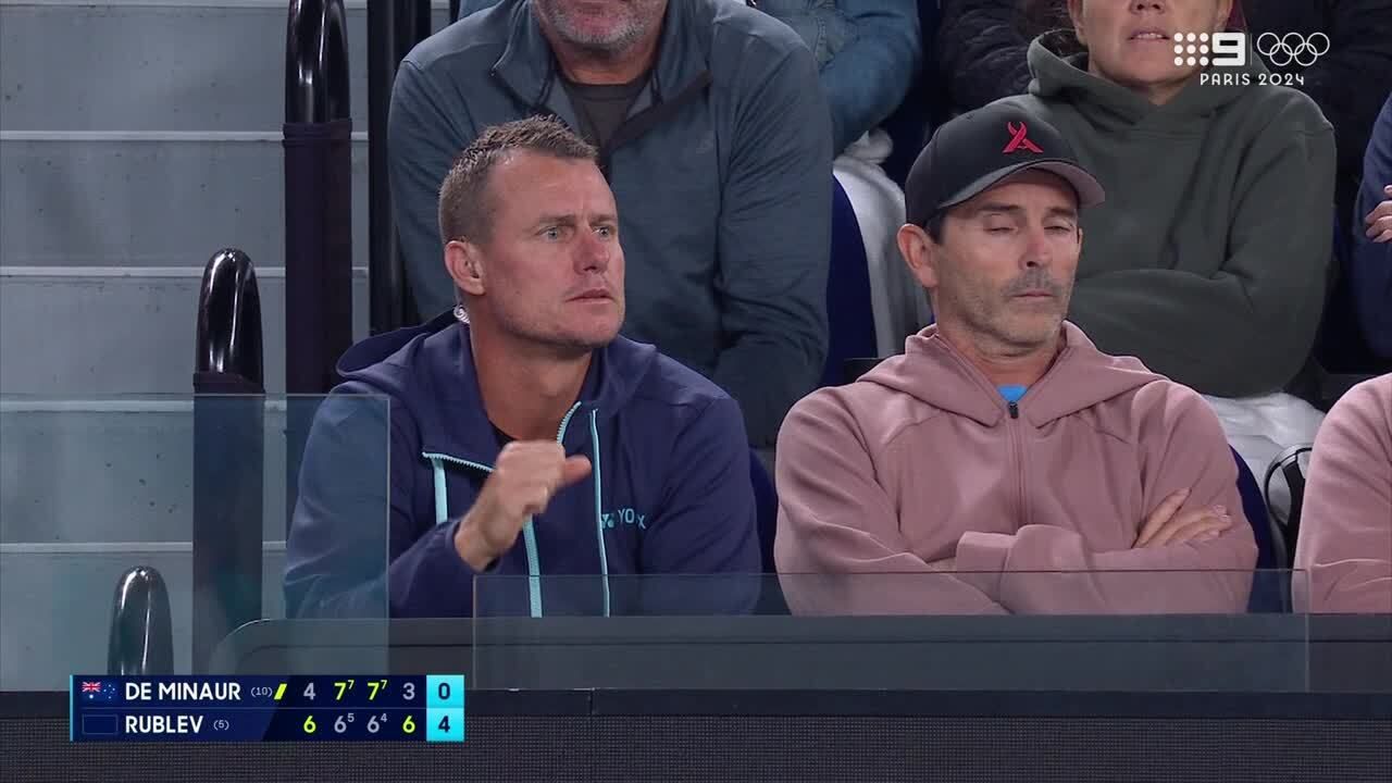 Lleyton Hewitt gestures to Alex de Minaur at the other end of the court as he picks up on Andrey Rublev cramping.