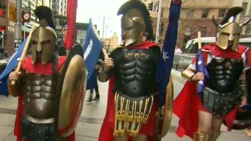 People dressed as Spartans and carrying Eureka flags in Martin Place. (9NEWS)